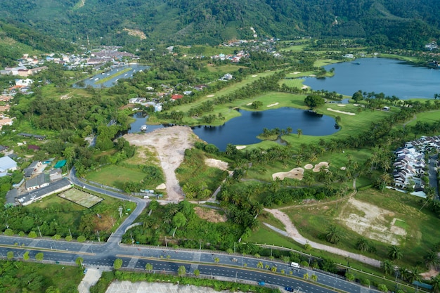 Strada asfaltata intorno alla foto verde del campo da golf dal colpo di Drone di vista aerea