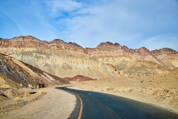 Strada asfaltata nera nella Valle della Morte che si snoda attraverso il deserto