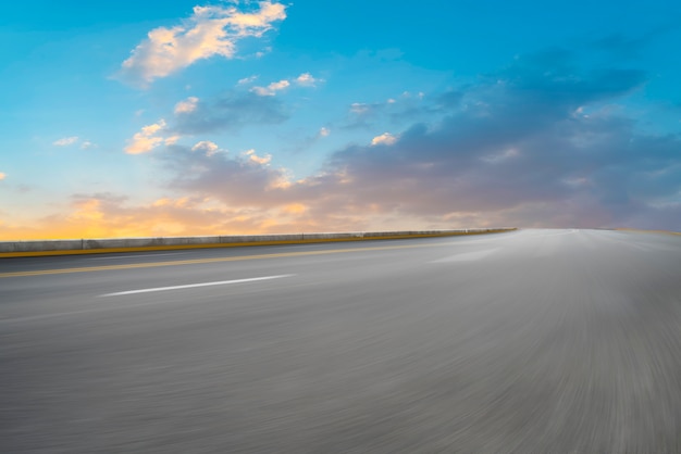 Strada asfaltata vuota e paesaggio naturale nel tramonto