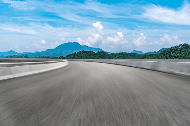 Strada asfaltata vuota e paesaggio naturale sotto il cielo blu