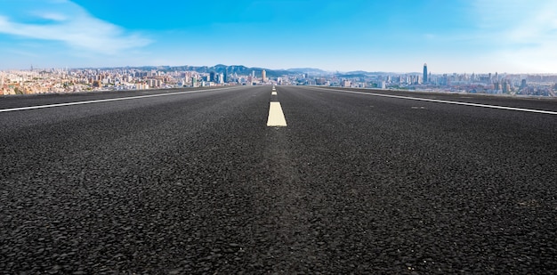 Strada asfaltata vuota e skyline della città e paesaggio edilizio, Cina.