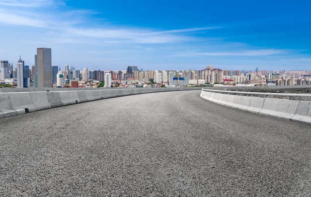 Strada asfaltata vuota e skyline della città e paesaggio edilizio, Cina.