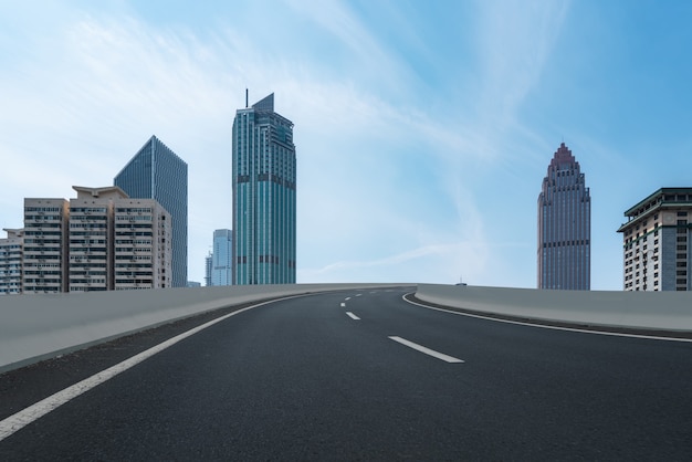 Strada asfaltata vuota e skyline della città e paesaggio edilizio, Cina.