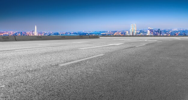 Strada asfaltata vuota e skyline della città e paesaggio edilizio, Cina.