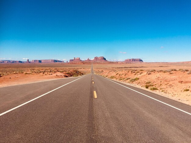 Strada che attraversa il deserto contro il cielo blu in Arizona