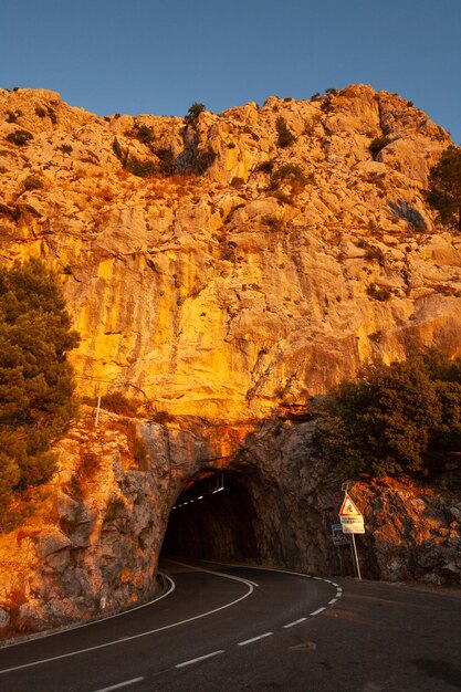 Strada che attraversa una formazione rocciosa contro un cielo limpido