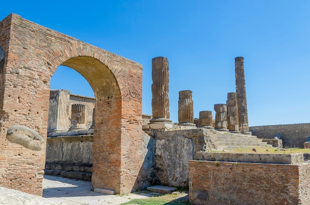 strada con arco e resti di colonne a Pompei