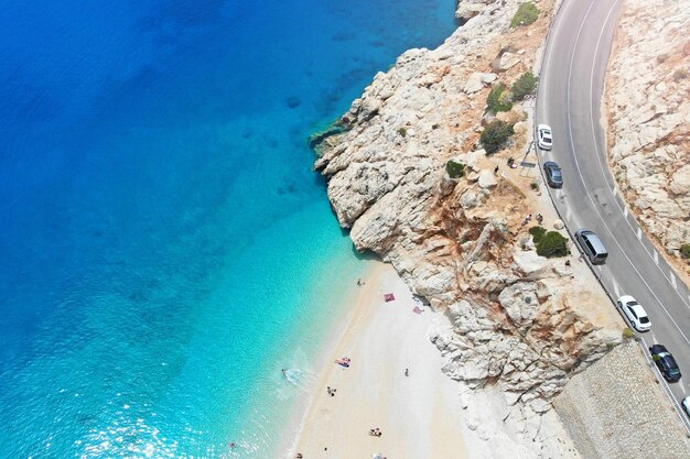 Strada con auto vicino alla spiaggia con acqua turchese