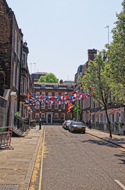 Strada con bandiere e architettura inglese tradizionale nel centro di Londra nel Regno Unito. Persone sullo sfondo