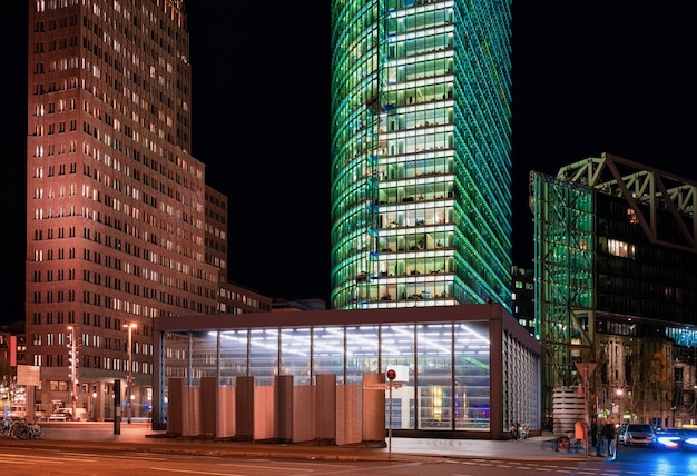 Strada con traffico automobilistico sulla stazione Bahnhof e architettura moderna dell'edificio in Potsdamer Platz Square nel centro di Berlino in Germania in Europa. Di notte