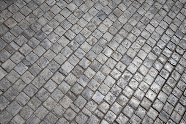 Strada della via della pietra grigia del mattone. Trama di pavimentazione