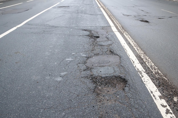 Strada di asfalto rotta in città e riparazione non tempestiva di buche stradale di asfaltato in cattive condizioni