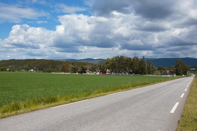 Strada di campagna vuota con le case su una collina a NorwayxA