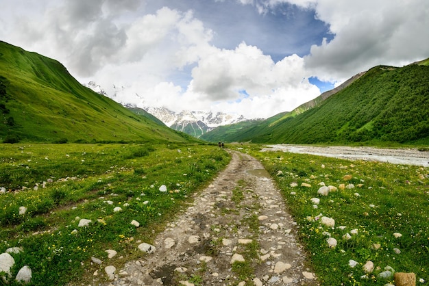 Strada di terra che porta verso le montagne contro il cielo