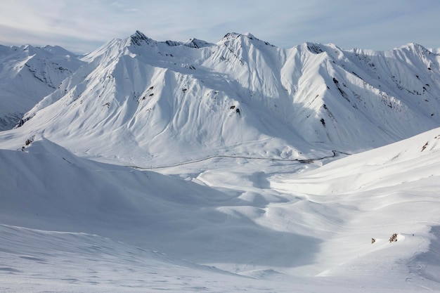 Strada estrema solitaria tra la neve bianca nelle alte montagne del Caucaso a Gudauri Georgia