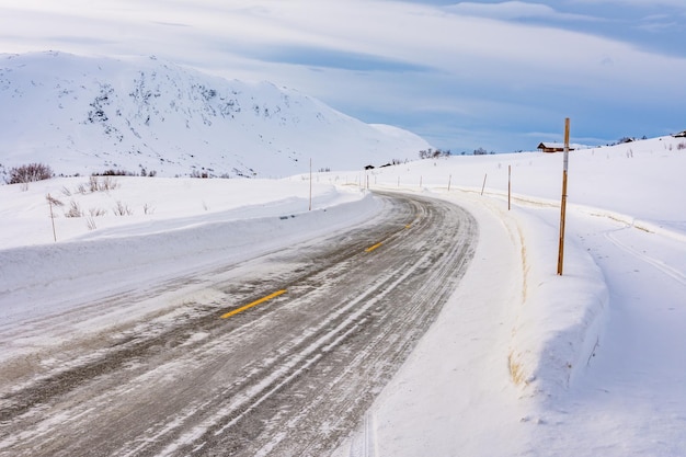 Strada ghiacciata con montagne innevate in Norvegia