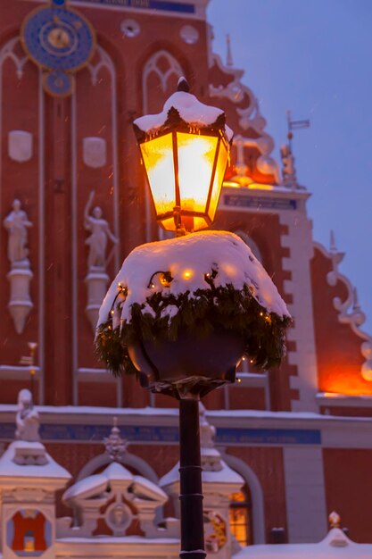 Strada illuminata in città Decorazioni natalizie nella città vecchia Riga Lettonia Edificio della Casa delle Teste Nere