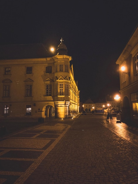 Strada illuminata in mezzo agli edifici della città di notte