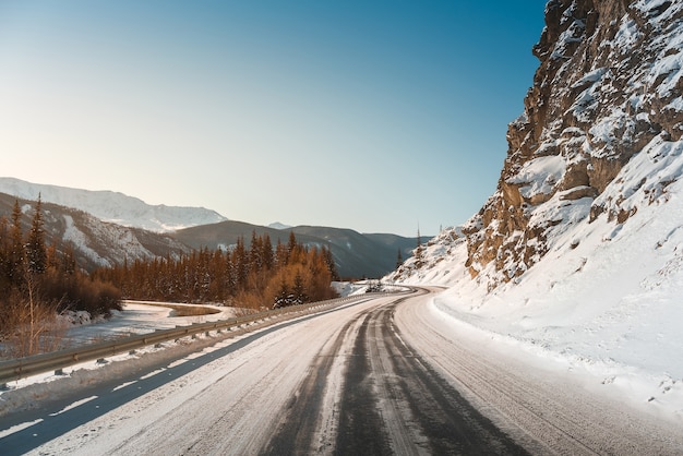 Strada invernale sulle montagne. Tramonto.