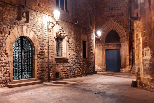 Strada medievale vuota acciottolata nel quartiere gotico di Barri di notte Barcellona Catalonia Spagna