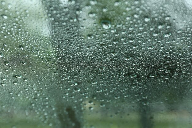 Strada nella giornata di pioggia vista attraverso il finestrino dell'auto bagnata