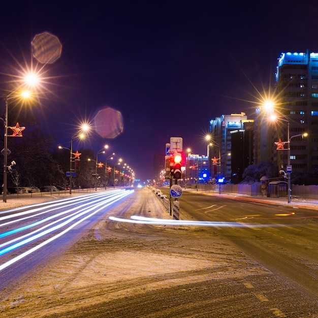 Strada nella notte invernale, città, automobili, luci, velocità.