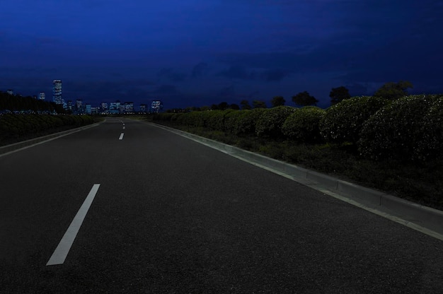 Strada notturna verso la città Strada asfaltata di notte