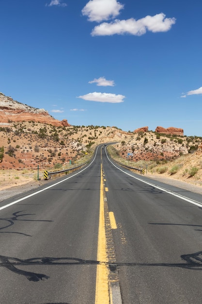 Strada panoramica nel deserto secco con montagne rocciose rosse sullo sfondo