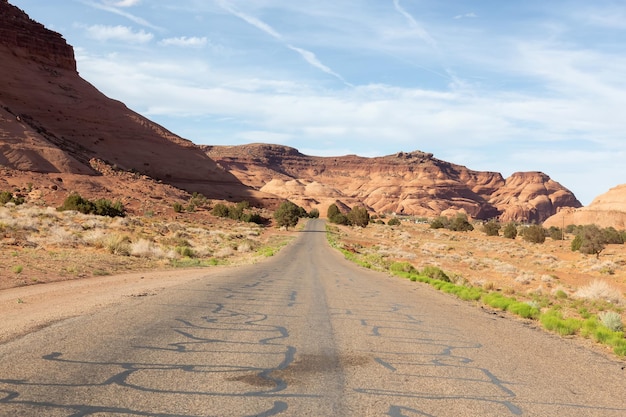 Strada panoramica nel deserto secco con montagne rocciose rosse sullo sfondo