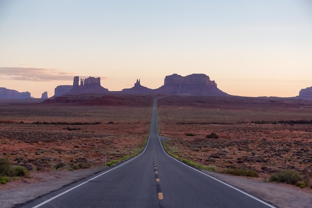 Strada panoramica nel deserto secco con montagne rocciose rosse sullo sfondo