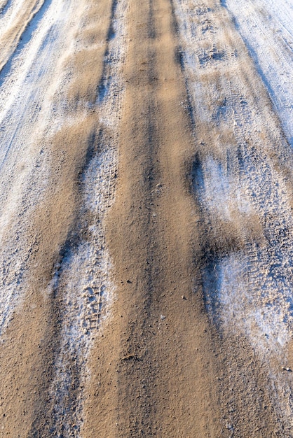 Strada pericolosa in inverno strada fangosa scivolosa con tracce di auto in inverno dopo la nevicata