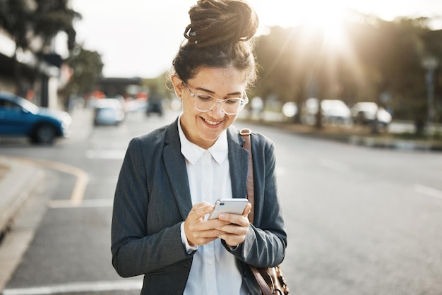 Strada professionale e donna con digitazione su smartphone e connessione internet per chat ed e-mail sui social media Viaggi di persone di sesso femminile o consulente con felicità telefonica e sms con informazioni sul sito web