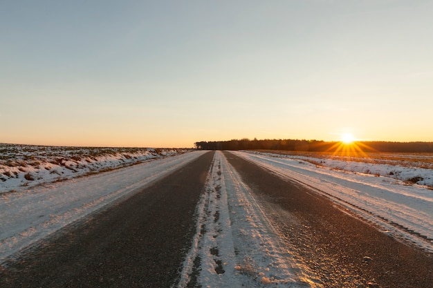 Strada rurale sotto la neve nell'orario invernale