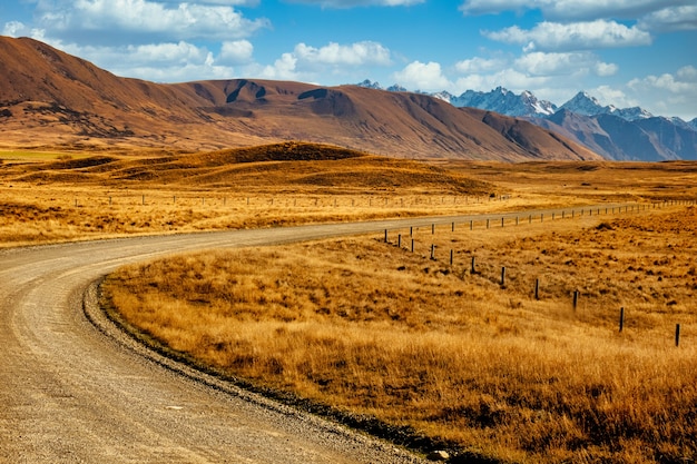 Strada sterrata che si snoda attraverso le valli e tra le alpi meridionali nel parco di conservazione di Hakatere nel distretto dei laghi di Ashburton