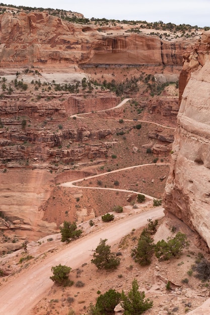 Strada sterrata panoramica circondata da montagne di roccia rossa nel canyon del deserto
