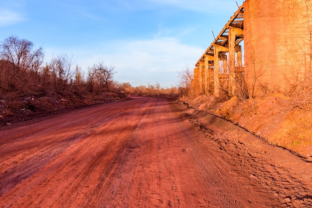 Strada sterrata rossa inquinata dal minerale di ferro. Inquinamento ambientale