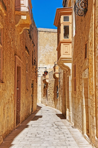 Strada stretta con lampada e balcone nella città vecchia di Mdina, Malta