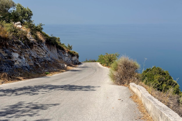 Strada stretta panoramica in montagna con una curva stretta e vista sul mare