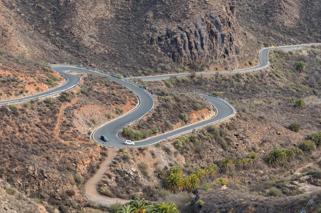 Strada tortuosa curva con due auto guida in montagna a Gran Canaria