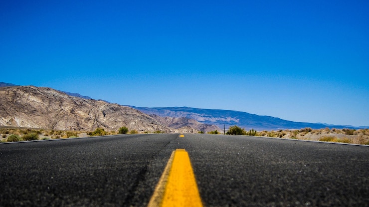 Foto strada tra le montagne contro un cielo blu limpido