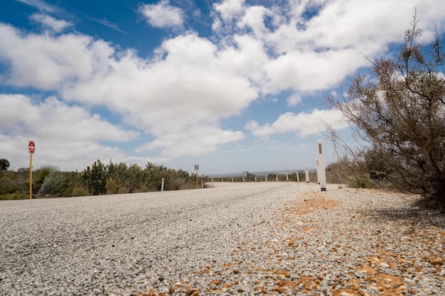 Strada verso il nulla con cielo azzurro e drammaticamente nuvoloso