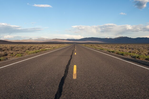 Strada vuota che attraversa il paesaggio contro il cielo