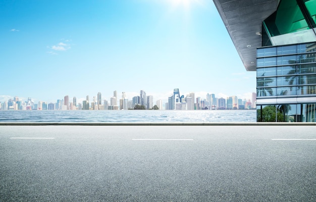 Strada vuota dell'asfalto della strada principale con l'architettura moderna e il fondo dell'orizzonte del mare della città.