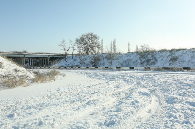 Strada vuota di campagna ricoperta di neve in giornata di sole