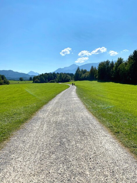 Strada vuota in mezzo al campo contro il cielo