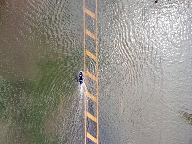 Strade allagate, persone con auto che passano. La fotografia aerea dei droni mostra le strade allagate e le auto delle persone che passano, spruzzi d'acqua.