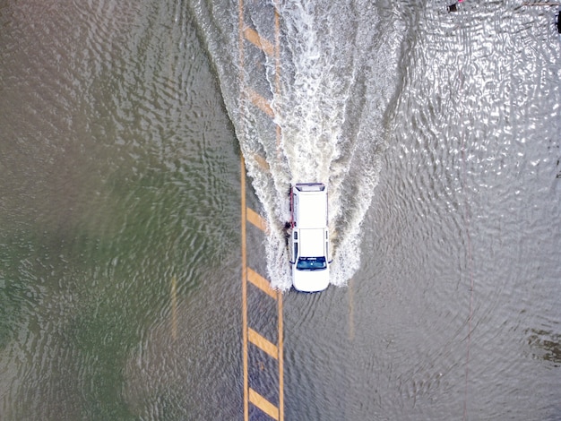 Strade allagate, persone con auto che passano. La fotografia aerea dei droni mostra le strade allagate e le auto delle persone che passano, spruzzi d'acqua.