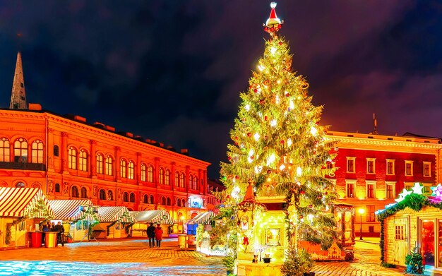 Strade nella città vecchia durante le celebrazioni natalizie nel mercatino di Natale Riga in Lettonia. Inverno. A tarda sera. Fiera di strada e di festa nella città europea Decorazione dell'Avvento con oggetti di artigianato su Bazaar