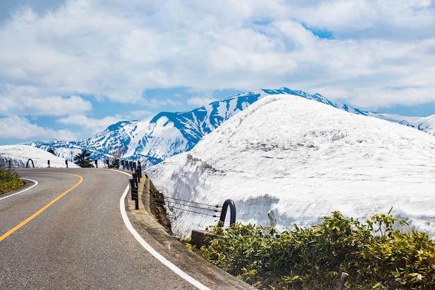 Strade tortuose con neve, montagne e il cielo blu in Giappone