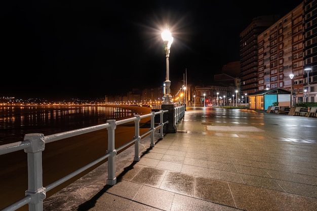 Strade vuote accanto al lungomare di Gijon di notte in un giorno di pioggia Asturie